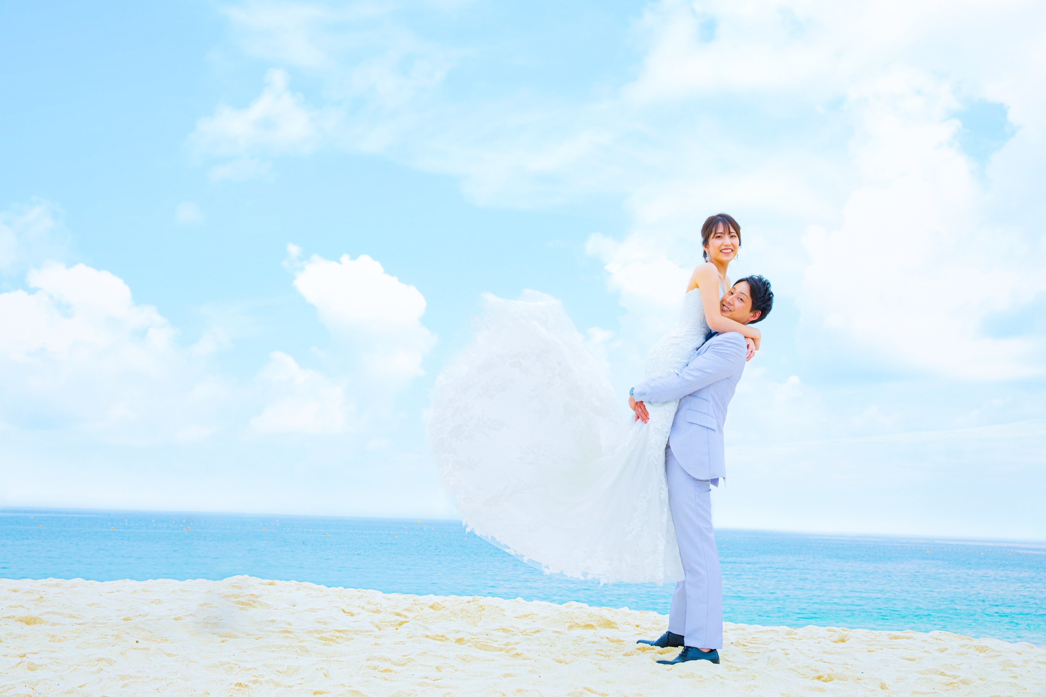 白良浜で新婦を抱き上げる新郎